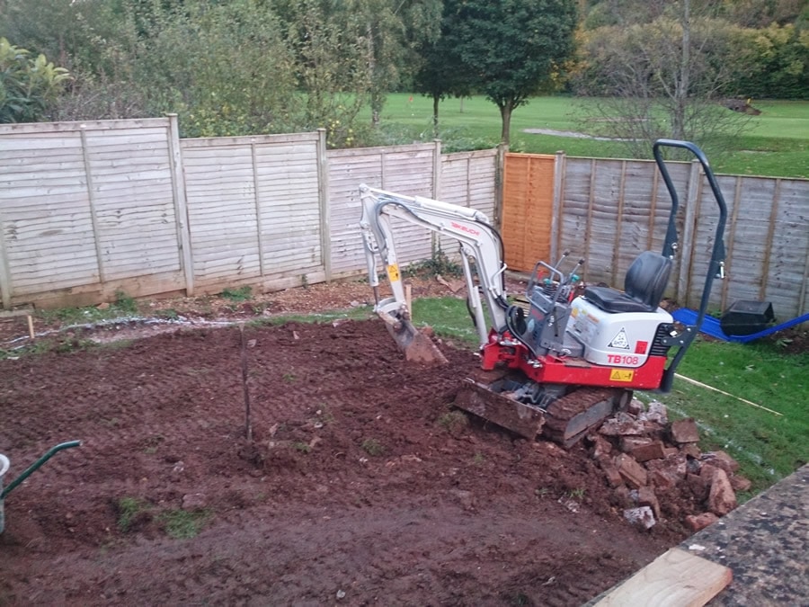 contouring a sloping garden using a mini digger and retaining walls