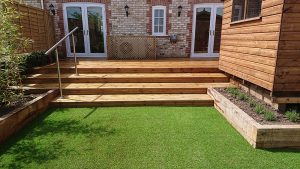 timber deck with steps leading down to artificial grass