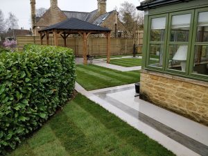 porcelain paved patios with turfed lawns in a contemporary garden
