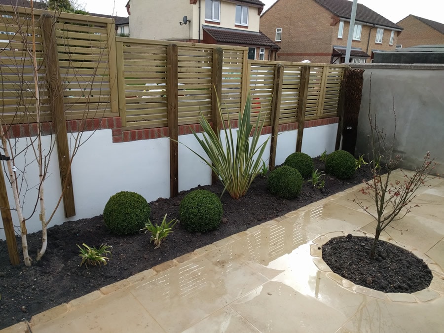 solid wall with laterally slatted fence on top