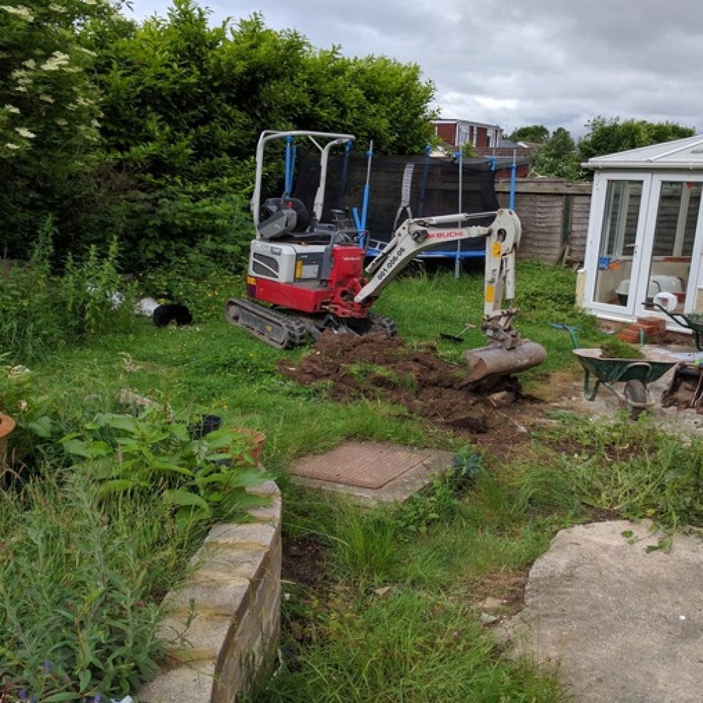 early stages of garden landscaping with mini digger clearing site