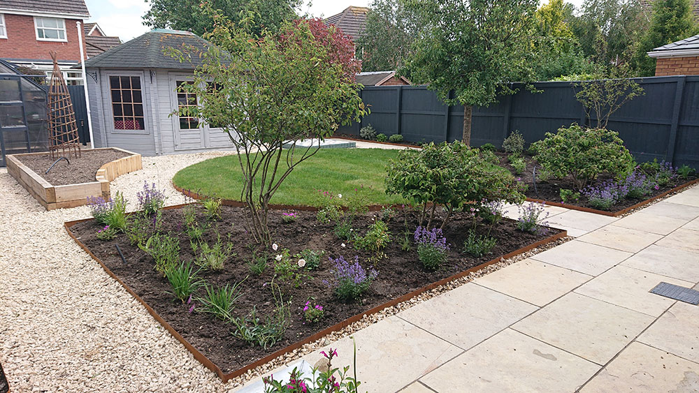traditional garden design with circular lawn and bee friendly planting