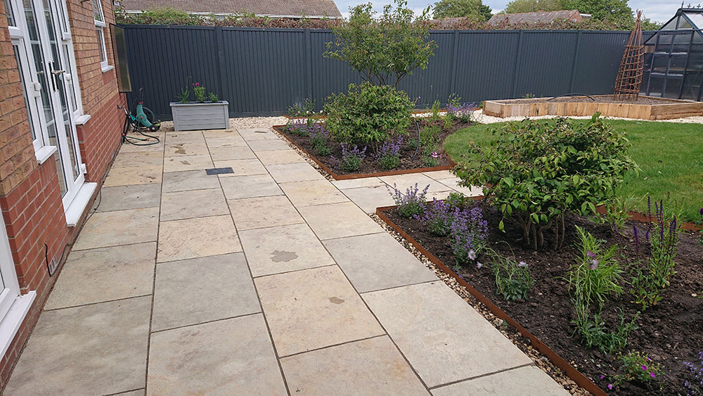 newly landscaped back garden with modern patio and country style planting