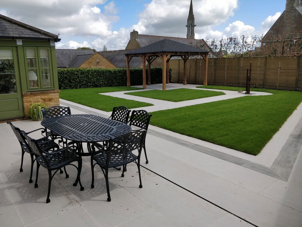contemporary garden with porcelain paving, pergola and lawn