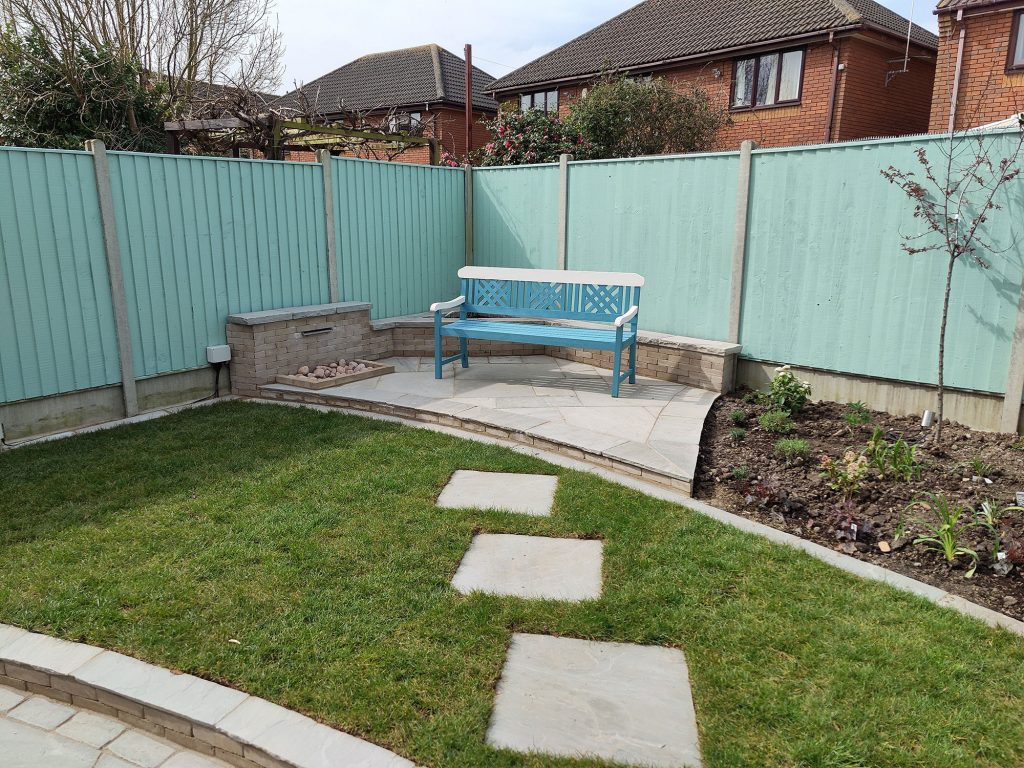 garden bench on a small patio in one corner of an overlooked garden