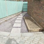 hard landscaping project with stepping stones leading from patio, down a narrow side return and around the house