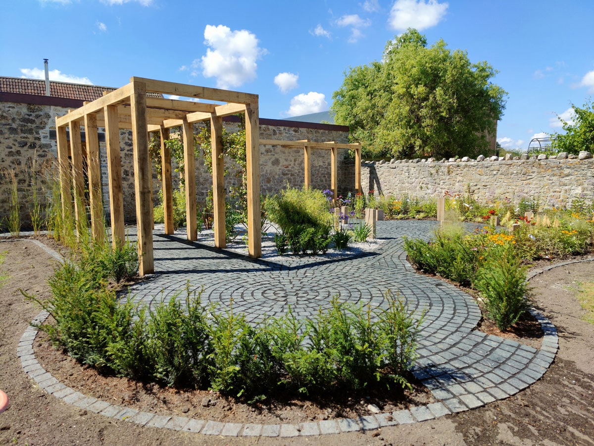 newly landscaped garden with timber pergolas forming walkways at 90 degrees to each other
