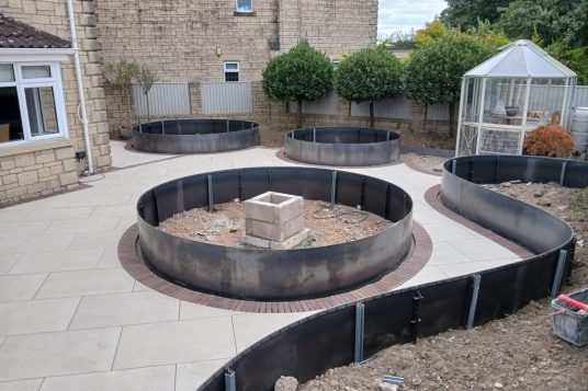 Curving raised beds and Porcelain paving